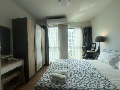 a hotel room with a bed with towels on it at Sunlit Nest Sukhumvit in Ban Khlong Samrong