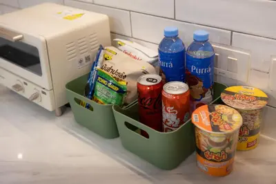 a kitchen counter with containers of food and a microwave at Peaceful Townhouse in Sathorn Near Saint Louis BTS in Yan Nawa