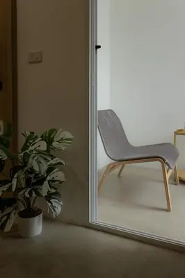 a chair in front of a mirror next to a plant at Peaceful Townhouse in Sathorn Near Saint Louis BTS in Yan Nawa