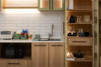 a kitchen with wooden cabinets and a counter top at Peaceful Townhouse in Sathorn Near Saint Louis BTS in Yan Nawa