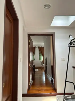 a hallway leading to a living room with white walls at Mookda House Chinatown BKK near MRT Samyot in Khlong San
