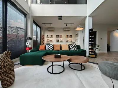 a living room with a green couch and a table at Thonglor 4-story modern art villa Free WiFi Netflix in Bangkok