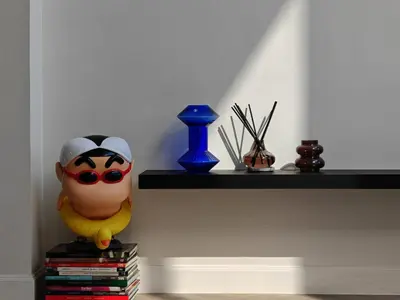 a shelf with a toy on a stack of books at Thonglor 4-story modern art villa Free WiFi Netflix in Bangkok
