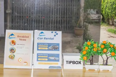 two signs on a table with a plant and a car rental at Skutan-MTB Bangchak in Bangkok