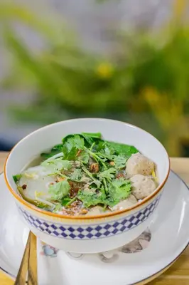 a bowl of soup on a plate on a table at Skutan-MTB Bangchak in Bangkok