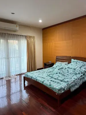 a bedroom with a bed and a wooden wall at Family home Don muang airport in Lak Si
