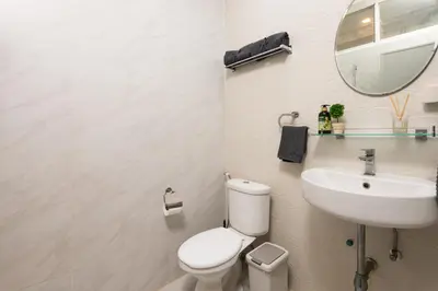 a bathroom with a toilet and a sink and a mirror at 3BR design townhouse in central Bangkok - 10min to BTS, Emquartier in Bangkok