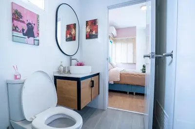 a bathroom with a toilet and a sink and a mirror at Bangkok Luxury Private Pool & Jacuzzi Villa , Daily Maid in Bang Bua Thong