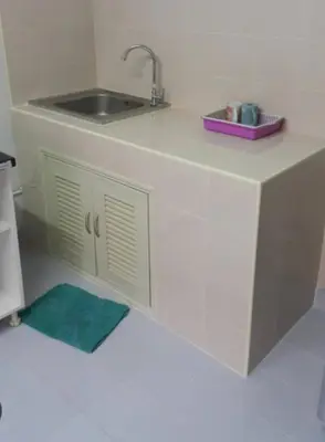a kitchen counter with a sink and a green rug at Popular Condo เมืองทองธานี in Thung Si Kan