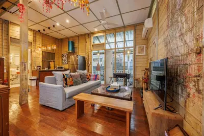 a living room with a couch and a tv at The Anonymous House in Bangkok