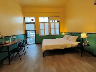 a bedroom with a bed and a table and a desk at During Moonshine Stay in Bangkok