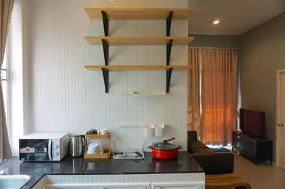 a kitchen with a counter top with a microwave at Family Friendly Home in Bangna