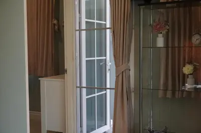 a glass door leading to a room with a window at Family Friendly Home in Bangna