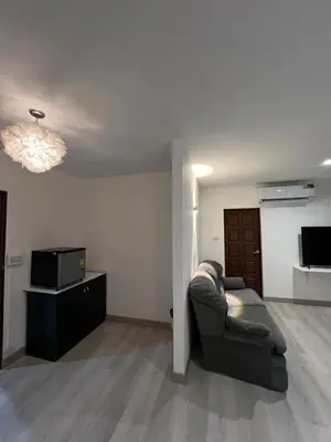 a living room with a couch and a television at Hotel Nanon Sathorn in Bangkok