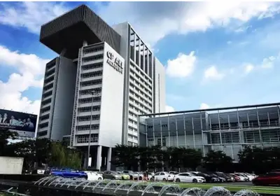 a large building with cars parked in a parking lot at Studio71 at changwattana in Ban Bang Phang