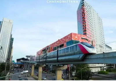 a train on a bridge in a city with buildings at Studio16 at Changwattana in Ban Bang Phang