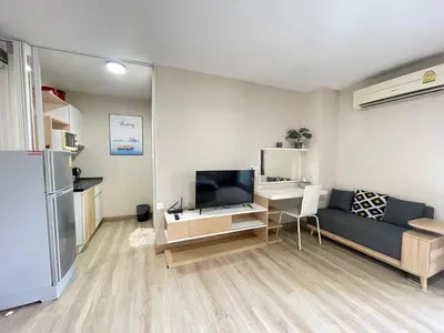 a living room with a blue couch and a television at Studio16 at Changwattana in Ban Bang Phang