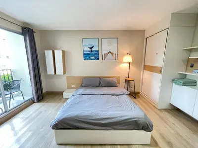 a bedroom with a bed and a lamp in it at Studio16 at Changwattana in Ban Bang Phang