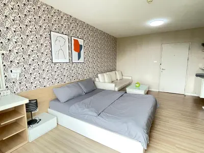 a bedroom with a large bed and a couch at Studio117 at Changwattana in Ban Bang Phang
