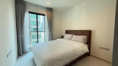 a bedroom with a large bed and a large window at Luxurious Downtown Apartment With Train Access Bts in Bangkok