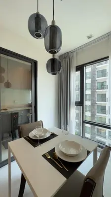 a dining room table with two plates and glasses on it at Luxurious Downtown Apartment With Train Access Bts in Bangkok