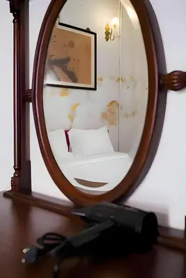 a mirror on top of a wooden table at XX Mitr Inn Yaowarat China town -มิตร อินน์ เยาวราช in Bangkok