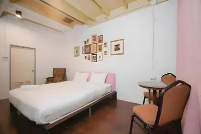 a bedroom with a bed and a table and a chair at XX Mitr Inn Yaowarat China town -มิตร อินน์ เยาวราช in Bangkok
