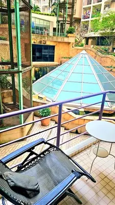a balcony with a chair and a table and a roof at River View Active 6 in Bangkok