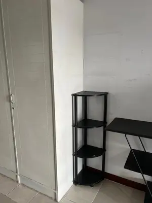 a black shelf next to a wall next to a door at Srivara condo Rachada in Bangkok