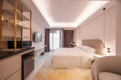 a hotel room with a bed and a tv at Wanda Jin Residences The Ease Sierra Bangkok in Bangkok