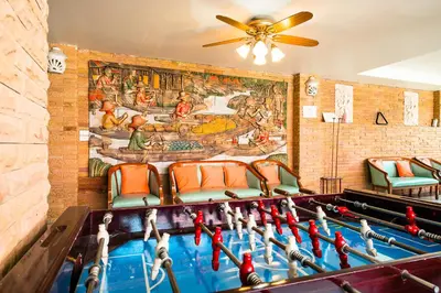 a ping pong table in a room with a mural at Sathorn View in Bangkok