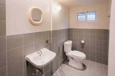 a bathroom with a toilet and a sink at Liver Bird Ratchada in Bangkok