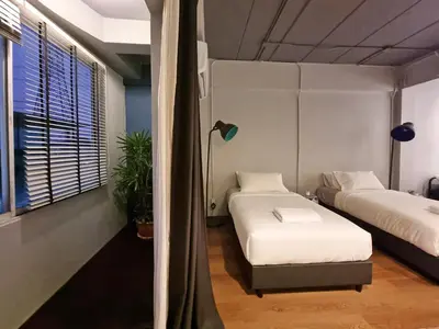 a room with two beds and a lamp at Human Touch Room - Soulful Bangkok Hideout in Lat Krabang