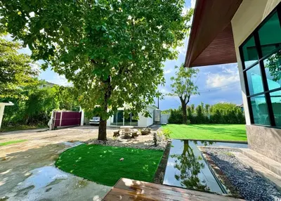 a backyard with a tree and a pond at Tarzan DZ Bangkok Luxurious Villa in Sathani Ban Hua Mak