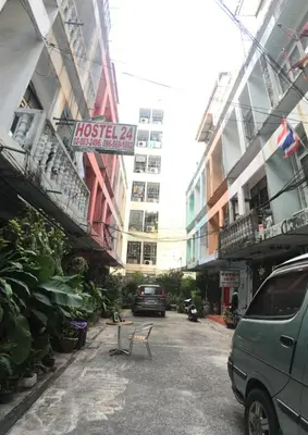 a street in a city with buildings and a van at Hostel 24 in Bangkok