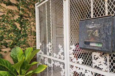 a door with a sign on the side of a building at Baan Nara 15 in Bangkok