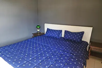 a bedroom with a blue bed with blue sheets and pillows at Baan Nara 15 in Bangkok