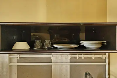 a shelf with plates and dishes on it at Baan Nara 15 in Bangkok