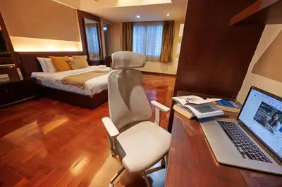 a room with a desk with a laptop and a bed at Low-Rise House for Groups Near BTS & EmDistrict For Spacious Cozy Stay in Bangkok