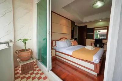 a bedroom with a bed and a potted plant at Low-Rise House for Groups Near BTS & EmDistrict For Spacious Cozy Stay in Bangkok