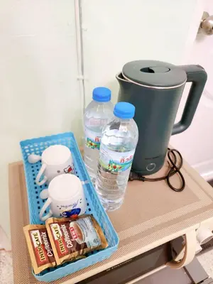 a table with a coffee pot and water bottles at 201-STP Homely room Free Wi-Fi and Near BTS in Sathani Bang Khen