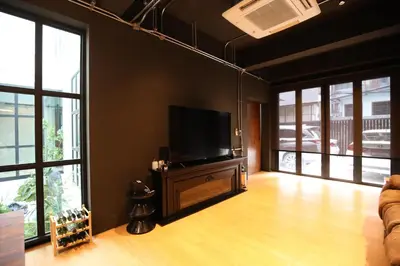a living room with a flat screen tv and windows at Chic Ekkamai Escape Near BTS, Dining & Nightlife in Bangkok