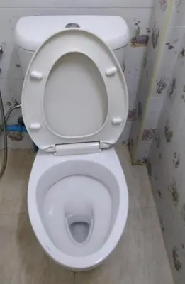 a white toilet with the lid up in a bathroom at Hostel 24 Backpackers in Bangkok