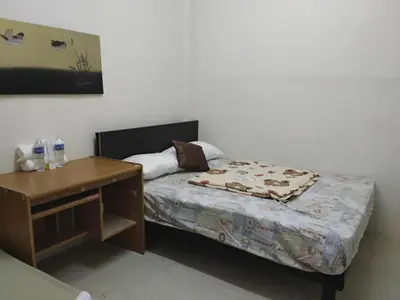 a small bedroom with a bed and a desk at Hostel 24 Backpackers in Bangkok