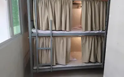 two bunk beds in a room with a window at Hostel 24 Backpackers in Bangkok