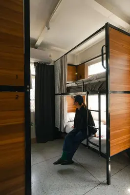 a woman sitting on a bunk bed in a room at nap in a blue moon in Bangkok