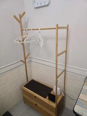 a wooden stand with a shelf and a clock at 103 Olan Place Peaceful Apartment near SkyTrain and free Wi-Fi in Bangkok