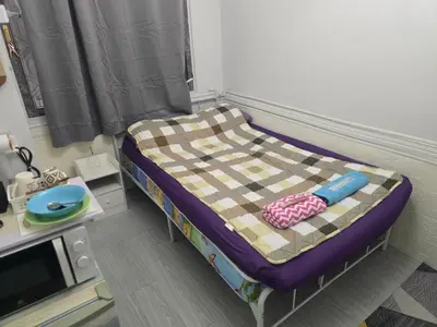 a small bed in a room with a table at 103 Olan Place Peaceful Apartment near SkyTrain and free Wi-Fi in Bangkok