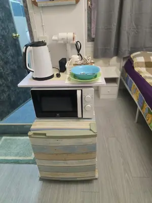 a microwave sitting on top of two books in a room at 103 Olan Place Peaceful Apartment near SkyTrain and free Wi-Fi in Bangkok