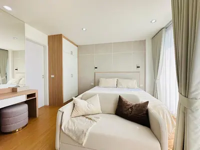 a bedroom with a white bed and a couch at 6th Avenue Sukhumvit BKK 407 BTS Asoke Nana in Bangkok